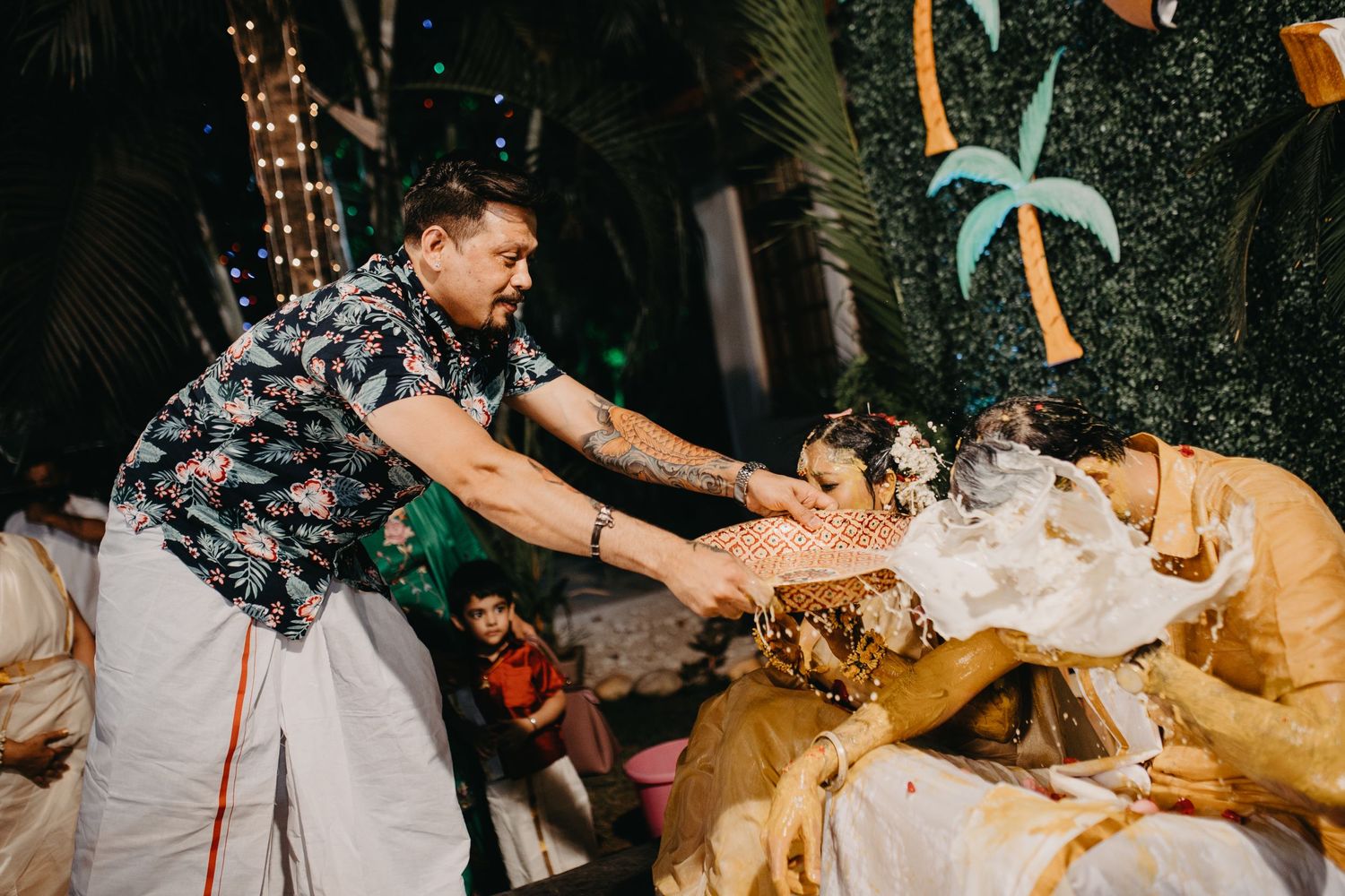 Guests celebrating with drinks and splashes at an outdoor nighttime party.