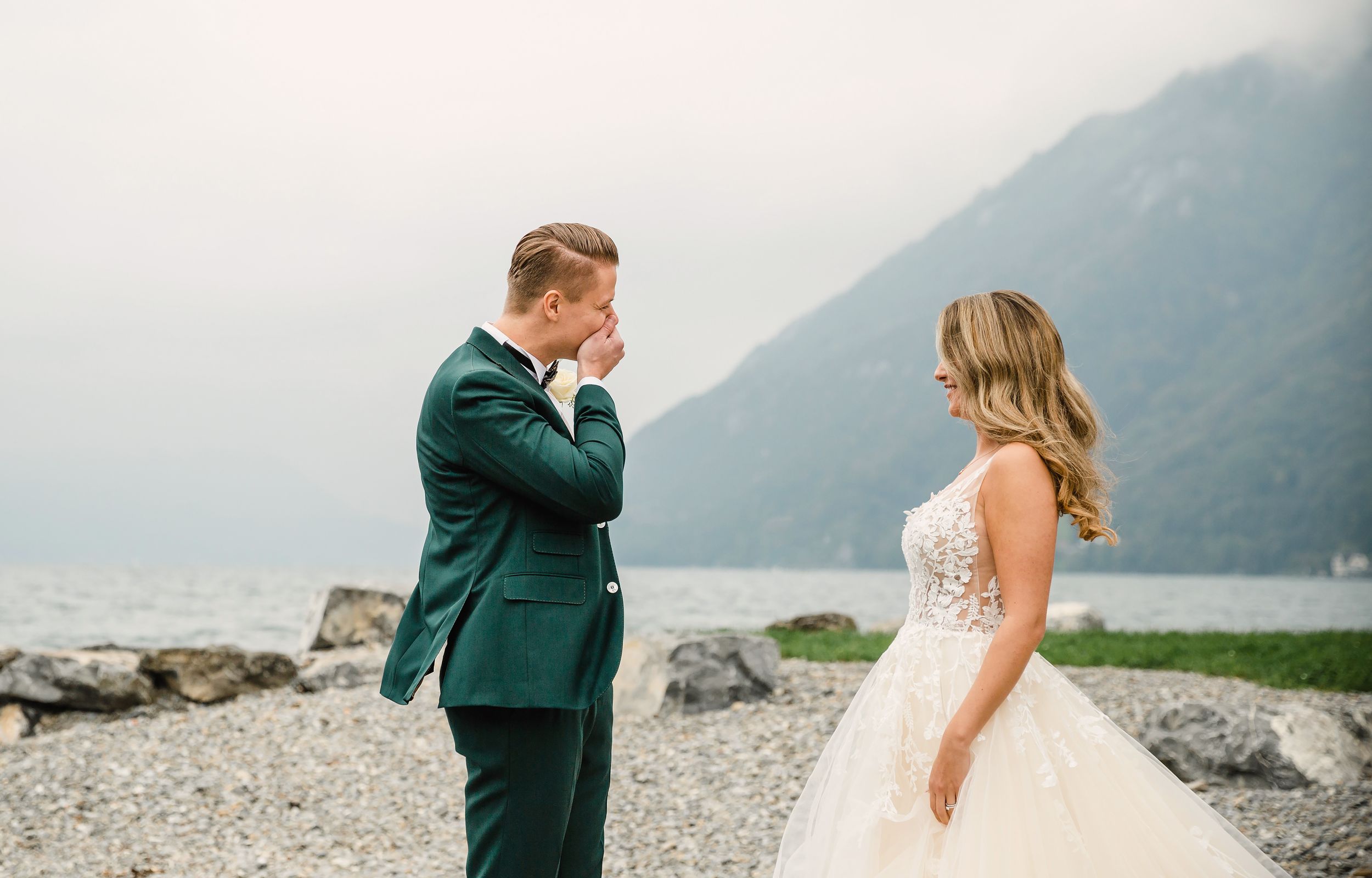 Candid moment of a groom smiling while looking at his bride during an outdoor wedding shoot.