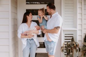 Family sharing joyful moment on front porch of white house.