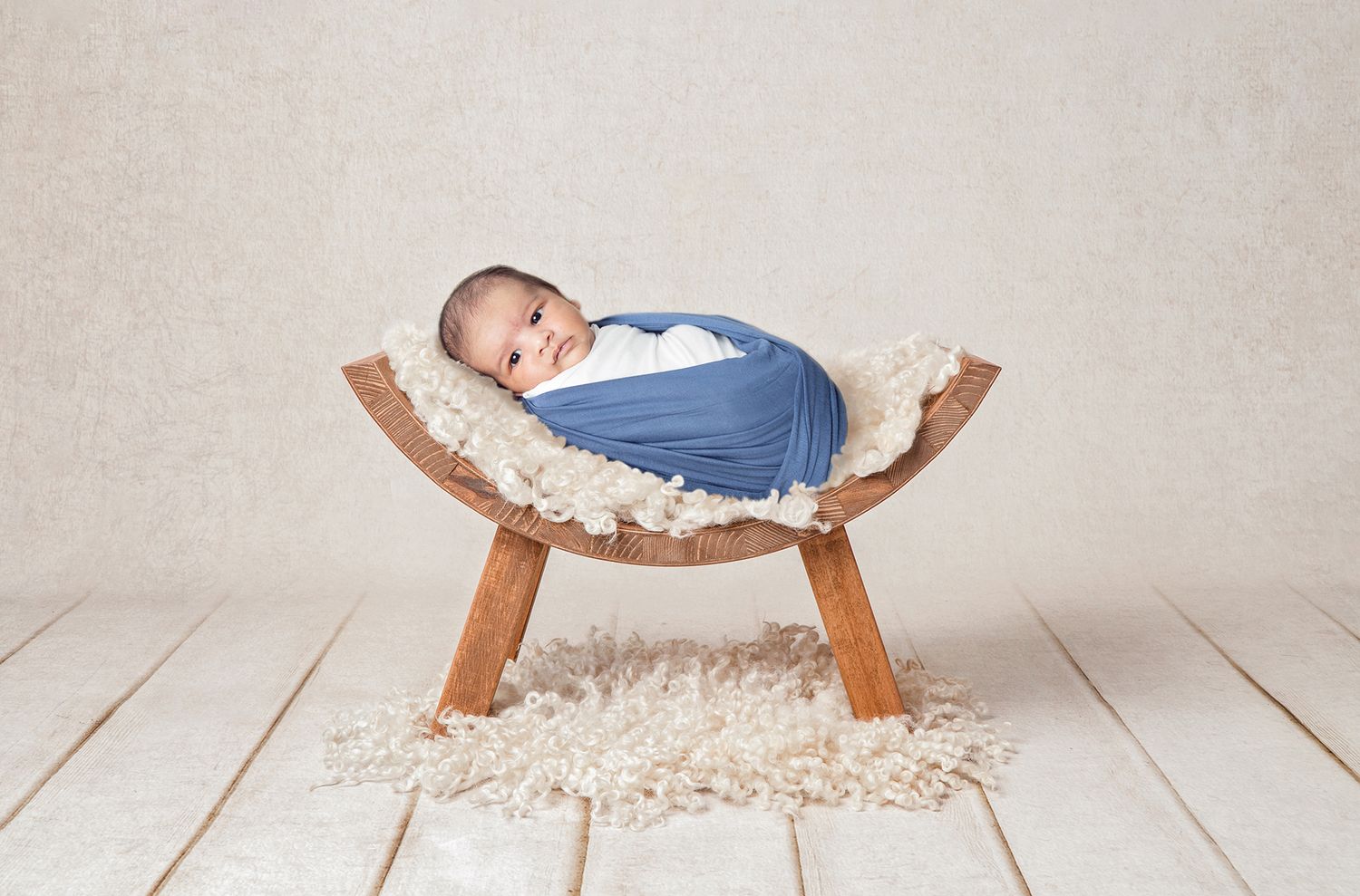 Creative newborn posing in a vintage bowl with soft wool textures.