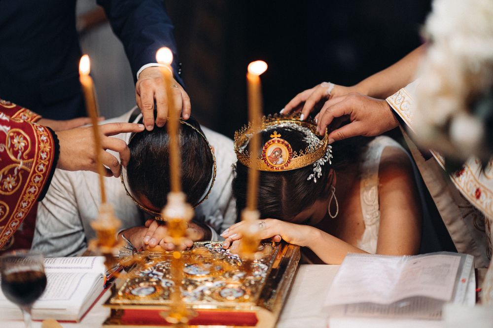 Close-up of traditional Orthodox wedding ceremony items including candles and ritual objects.
