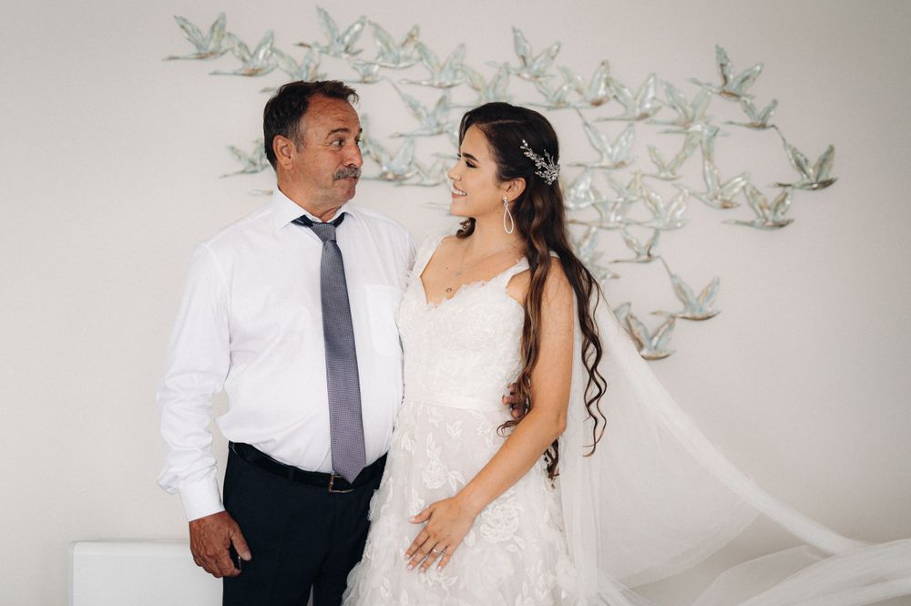 Wedding portrait in front of decorative wall art featuring delicate paper cranes.