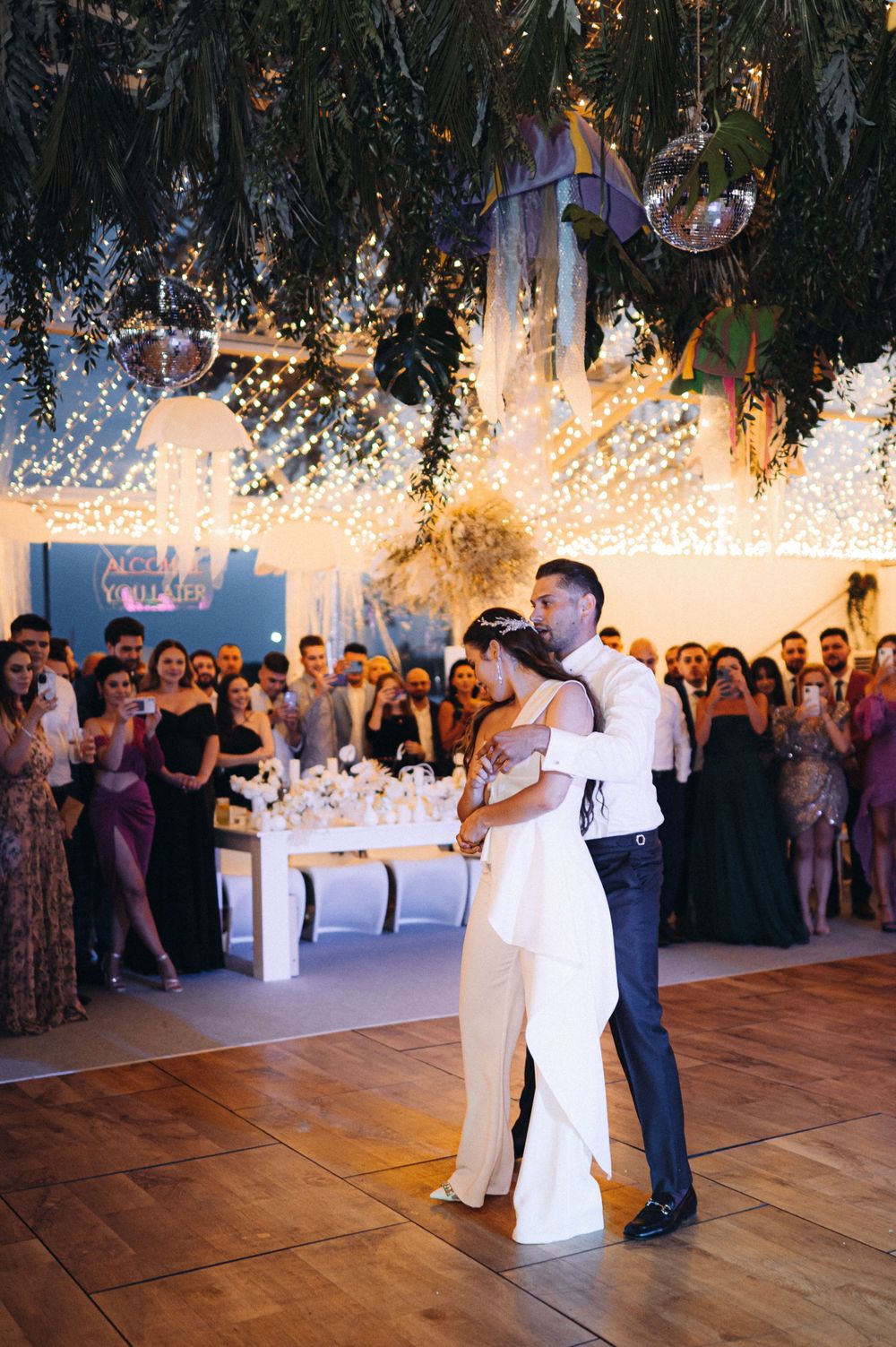 Couple shares their first dance under sparkling lights at wedding reception.