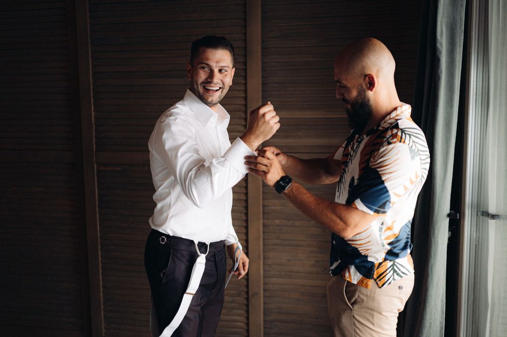 Two people getting ready and adjusting formal wear in casual interaction.