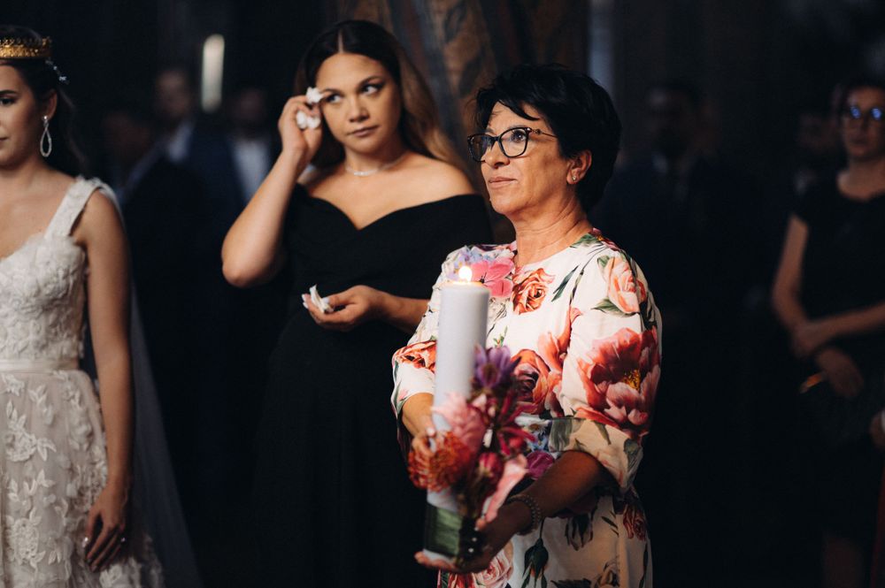 Elegant wedding guests in formal attire during an indoor ceremony reception.
