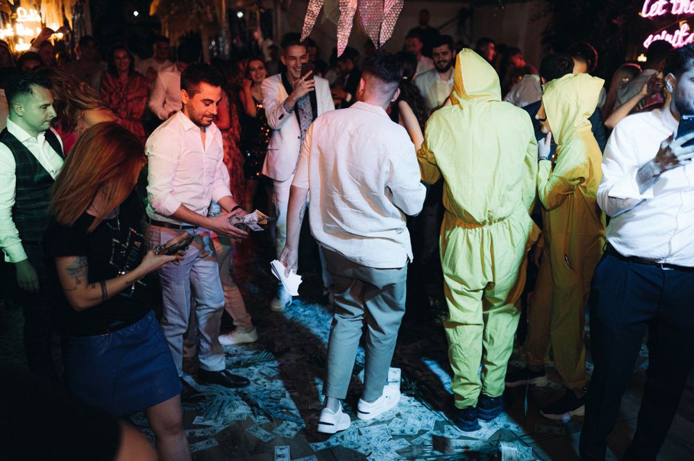 Lively party scene with crowd dancing under colorful lighting.