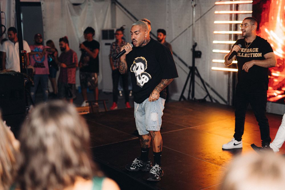 Casual dancer performing on illuminated dance floor with audience watching.