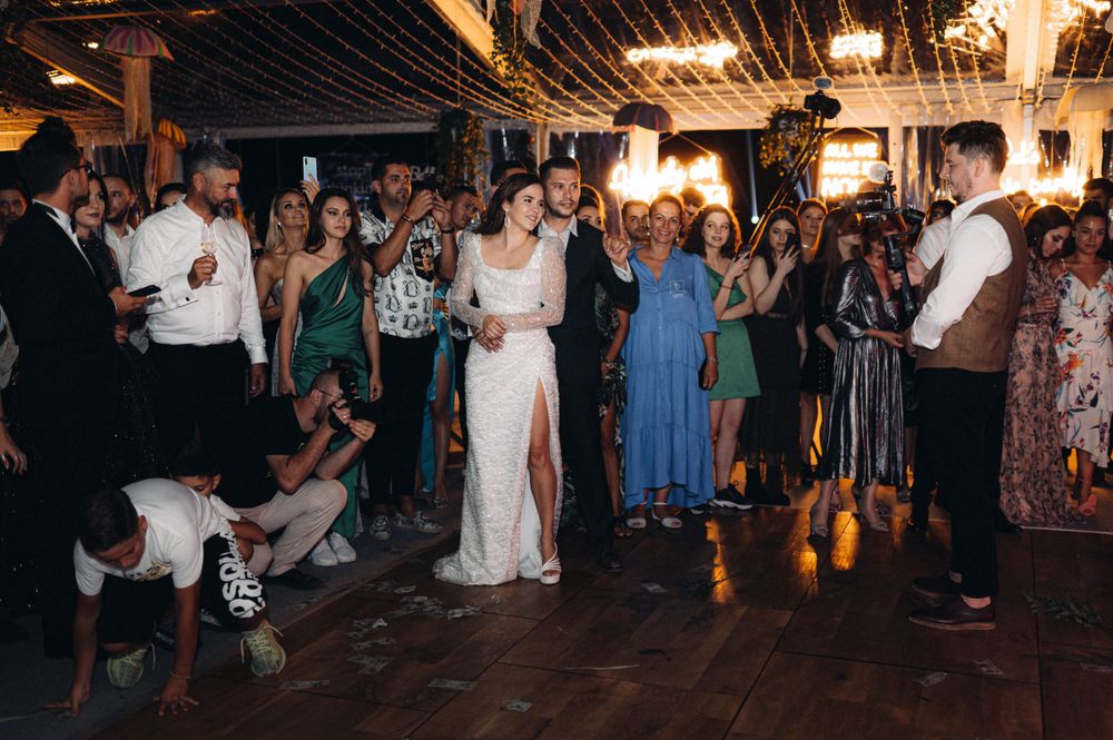 Wedding reception dance floor filled with guests celebrating at a rustic indoor venue.