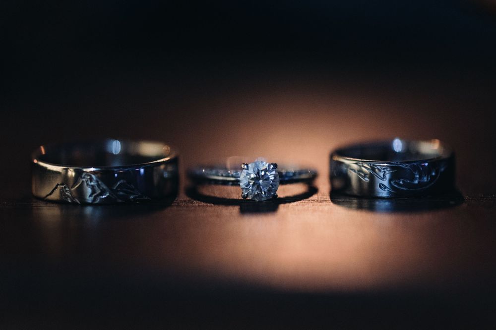 Three black wedding rings artistically photographed with dramatic lighting.