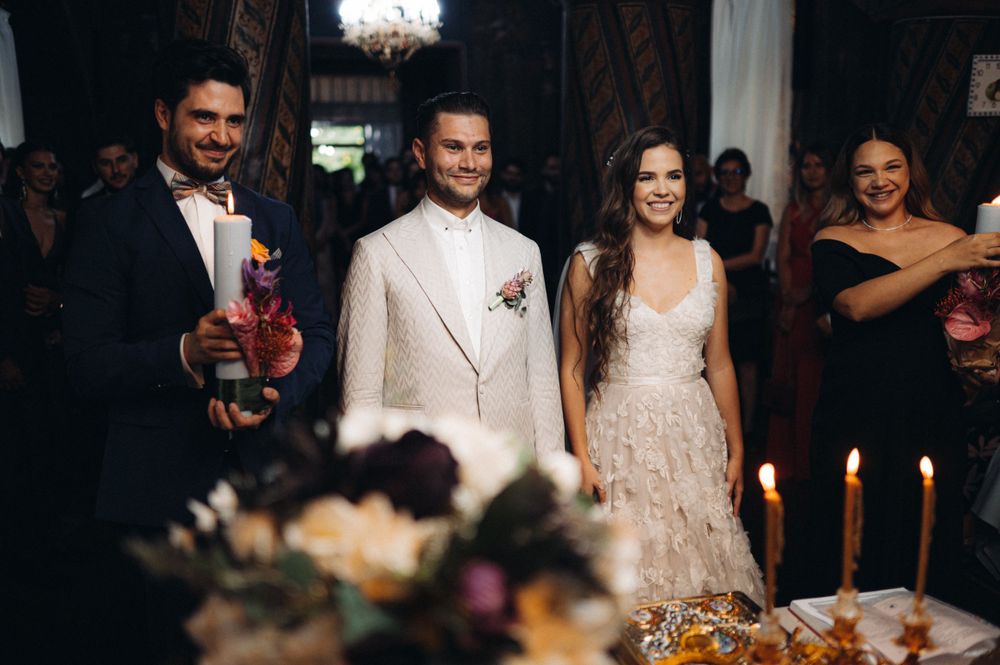 Elegant wedding celebration with guests in formal attire gathered around candlelit table.