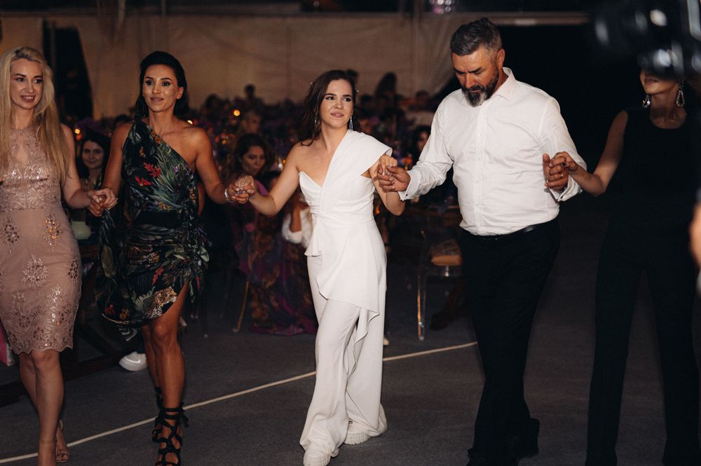 People dancing together in formal attire at an elegant indoor celebration.