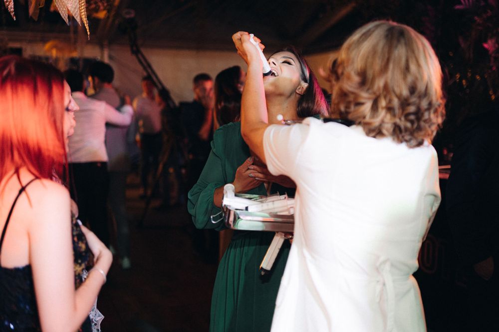 Party guests dance and celebrate on crowded dance floor at evening event.