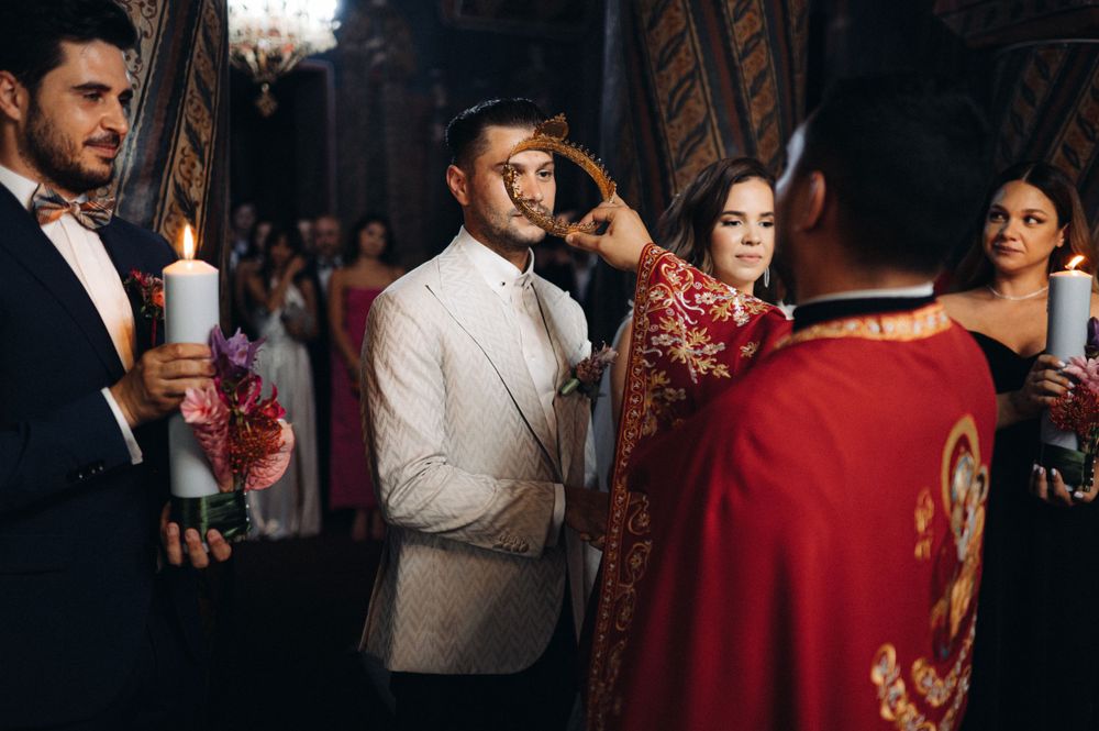 Wedding ceremony participants holding candles during an Orthodox Christian religious service.