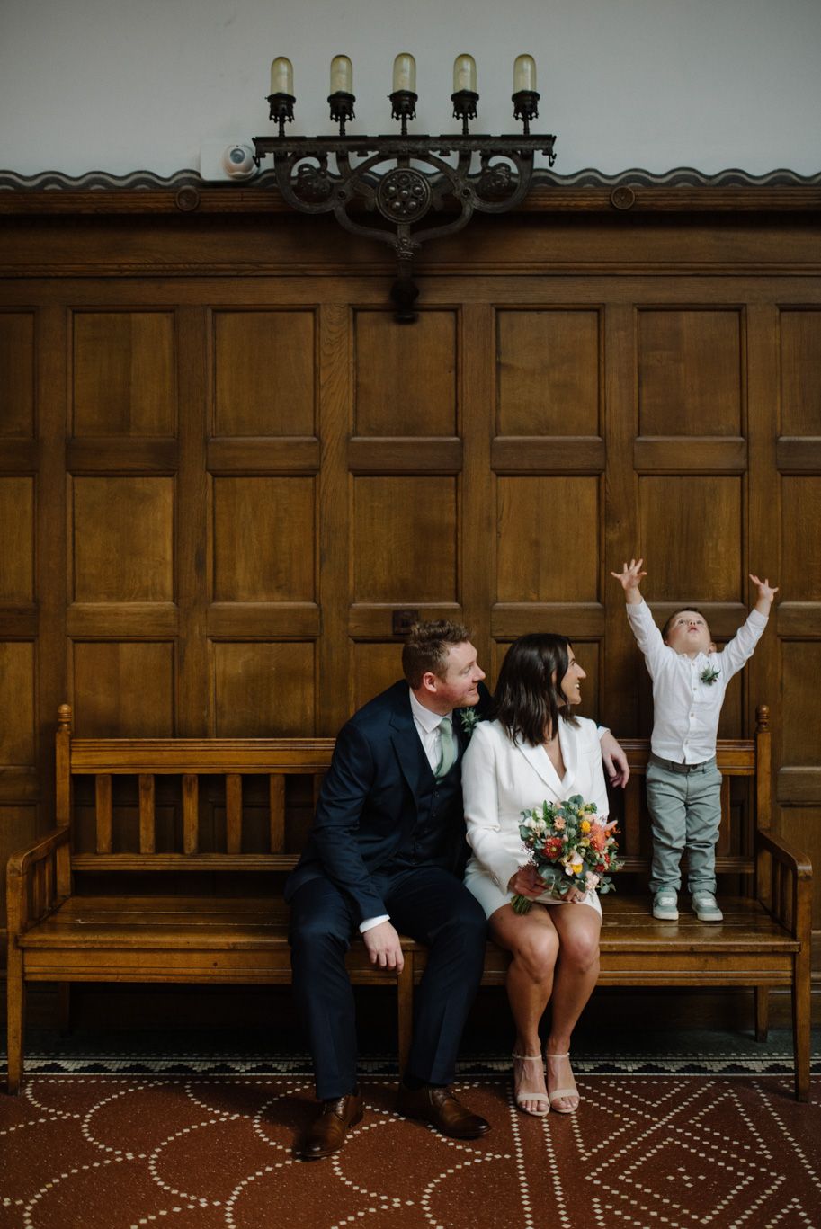 A couple on their wedding day with their child celebrating in Copenhagen City Hall
