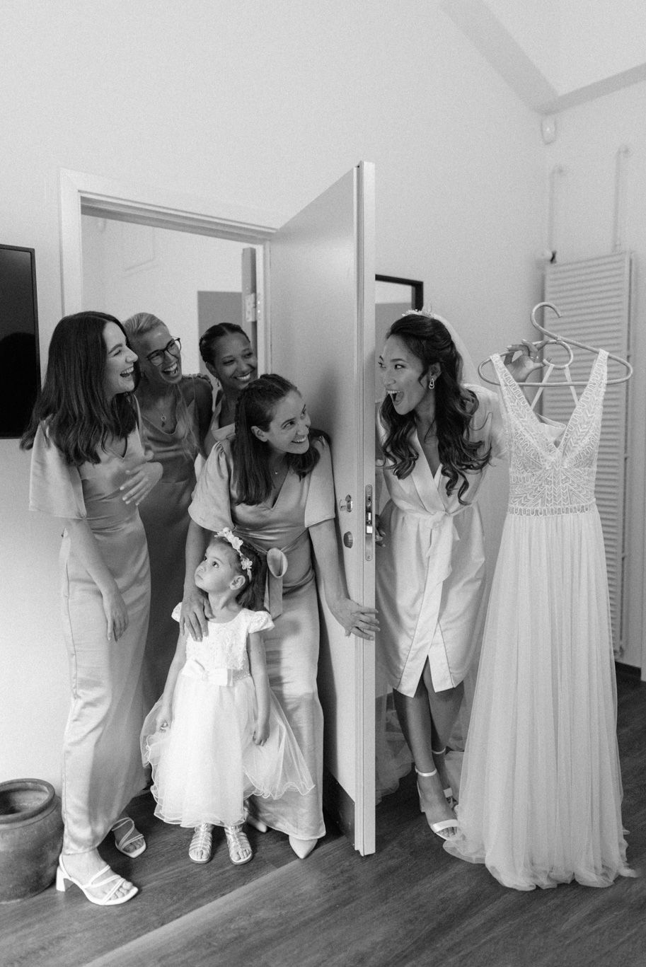 A bride on her wedding day showing her dress to her bridesmaids at Lystskoven in Denmark