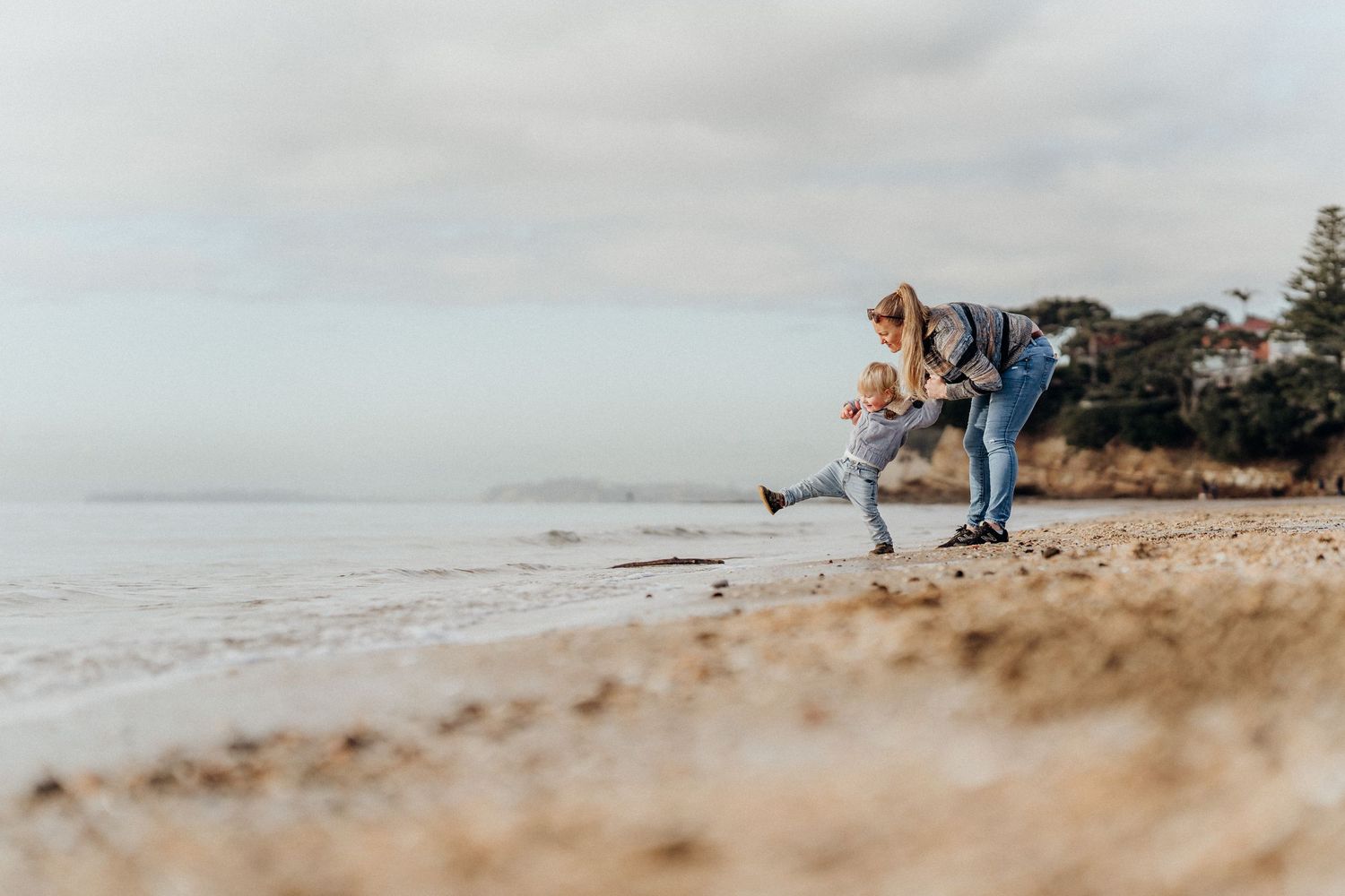 A mother and child playing on a beach