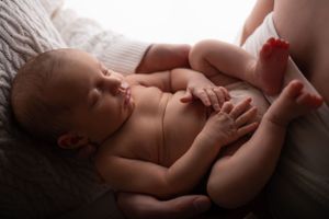 A natural newborn portrait showing a sleeping baby in gentle window light.