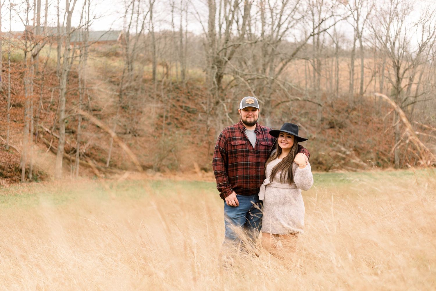 Couple embraces in a golden field during autumn photo session.