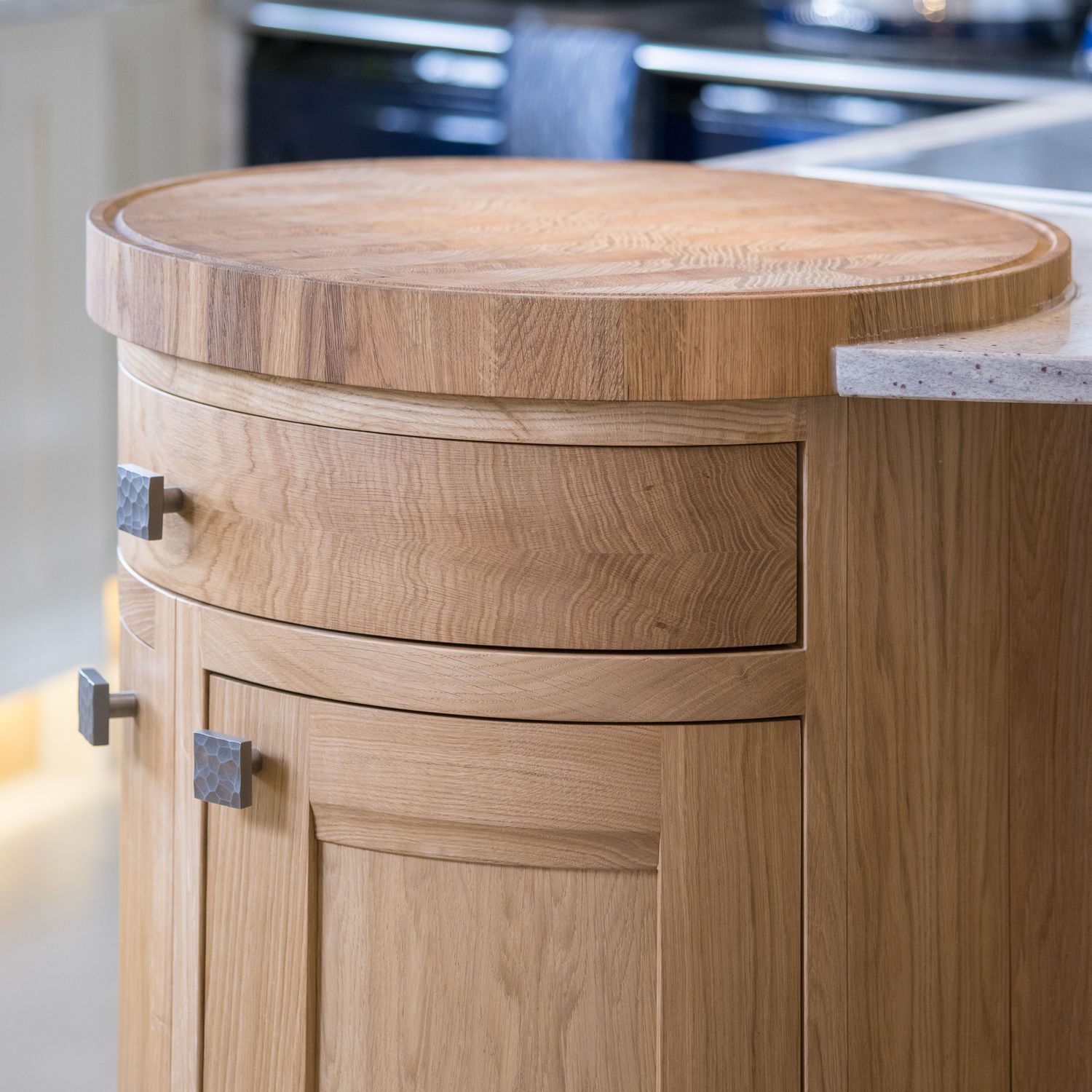 Curved oak cabinet with wooden handles features rounded corners and traditional craftsmanship details.