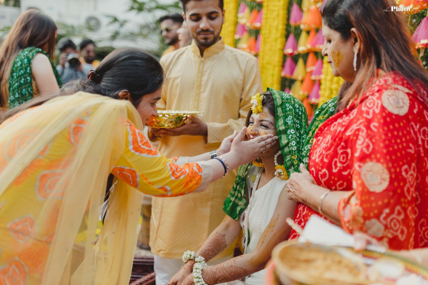 Traditional Haldi ceremony with yellow decorations and guests applying turmeric paste during celebrations.