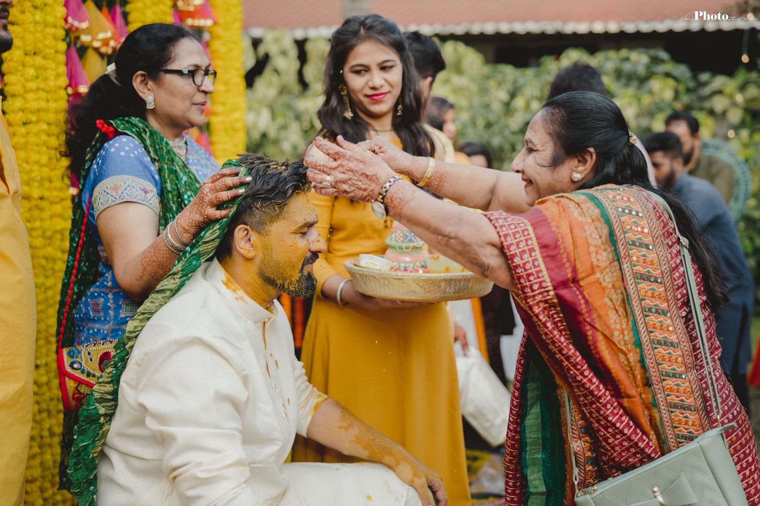 Traditional Indian wedding celebration with yellow floral decorations and colorful attire.