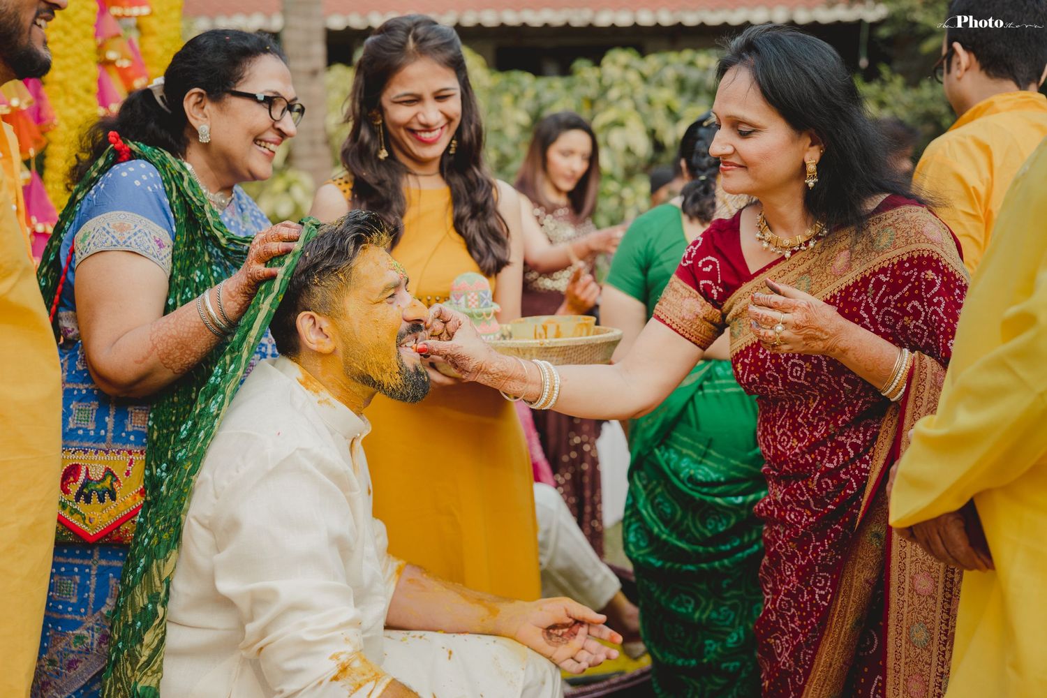 Guests celebrate at a vibrant Indian Haldi ceremony with yellow turmeric powder and colorful traditional attire.