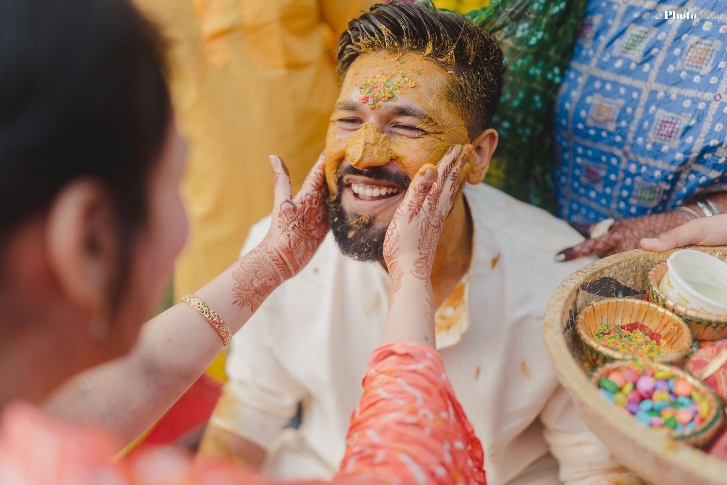 Celebratory moments at a traditional Haldi ceremony with guests applying turmeric paste.
