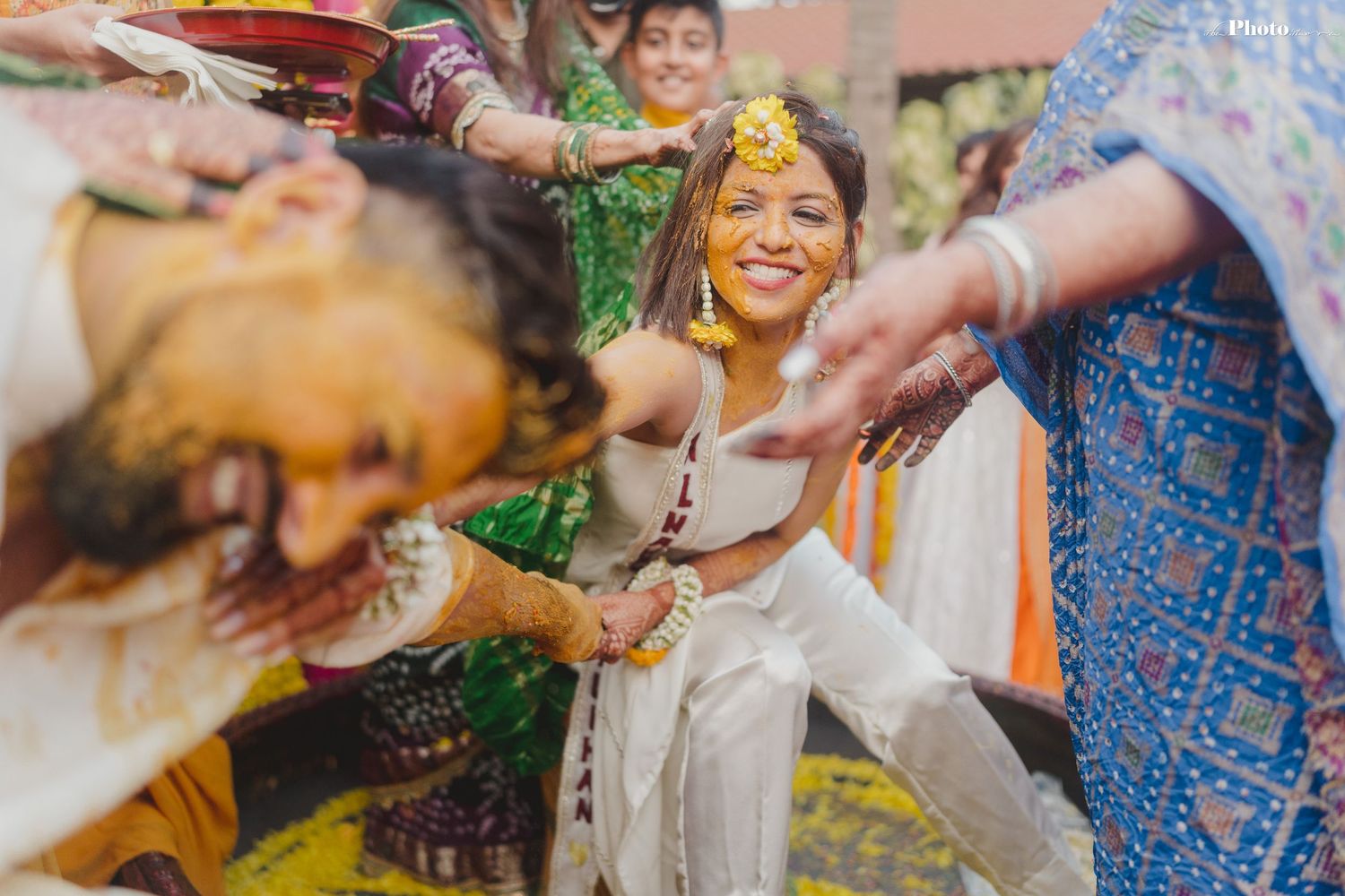 Guests participate in applying turmeric paste during a traditional Indian ceremony.