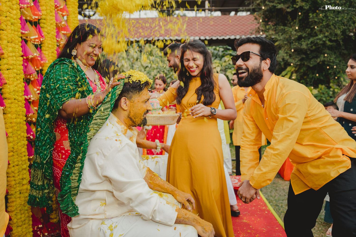 Outdoor Haldi celebration with yellow marigold decorations and traditional ceremonial elements.