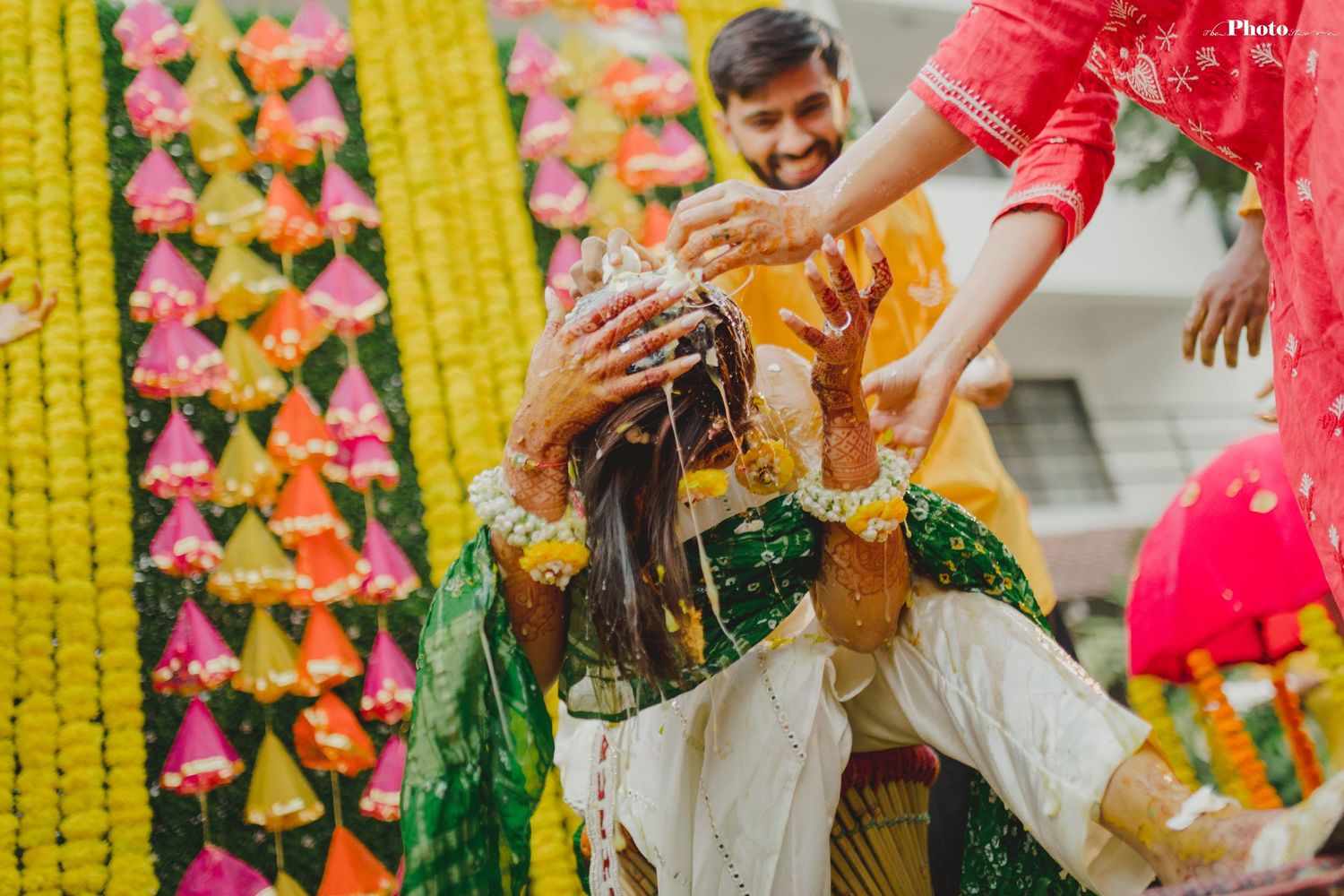 Festive outdoor ceremony with yellow and pink floral decorations and traditional celebrations.