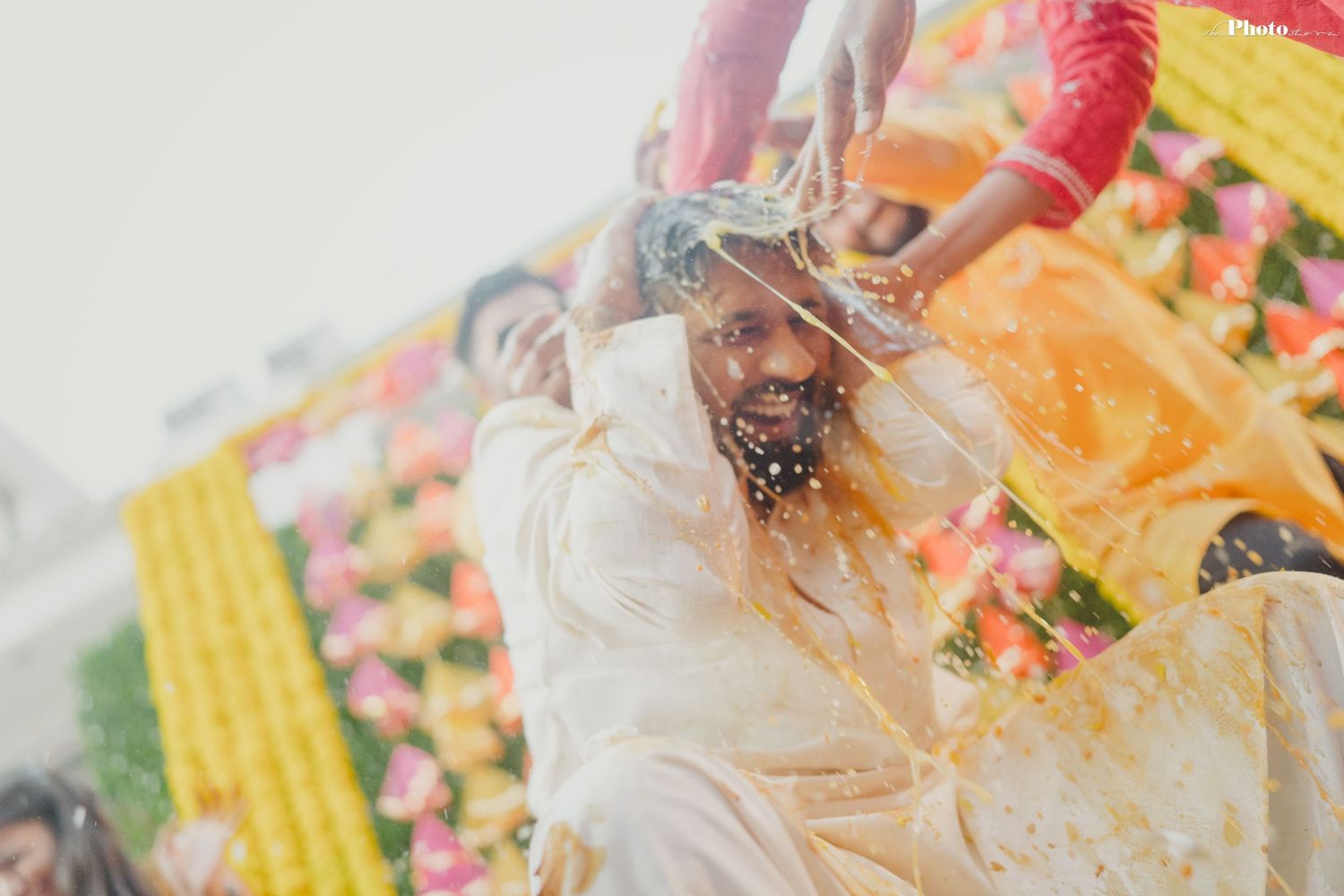 Close-up details of hands applying turmeric paste during a traditional Haldi ceremony.