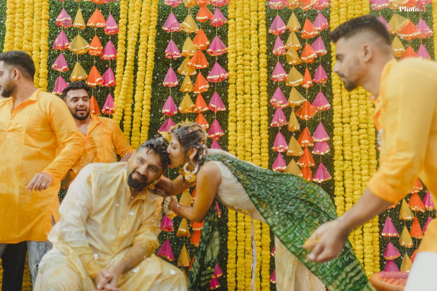 Joyous celebration with yellow and pink floral decorations hanging in the background.
