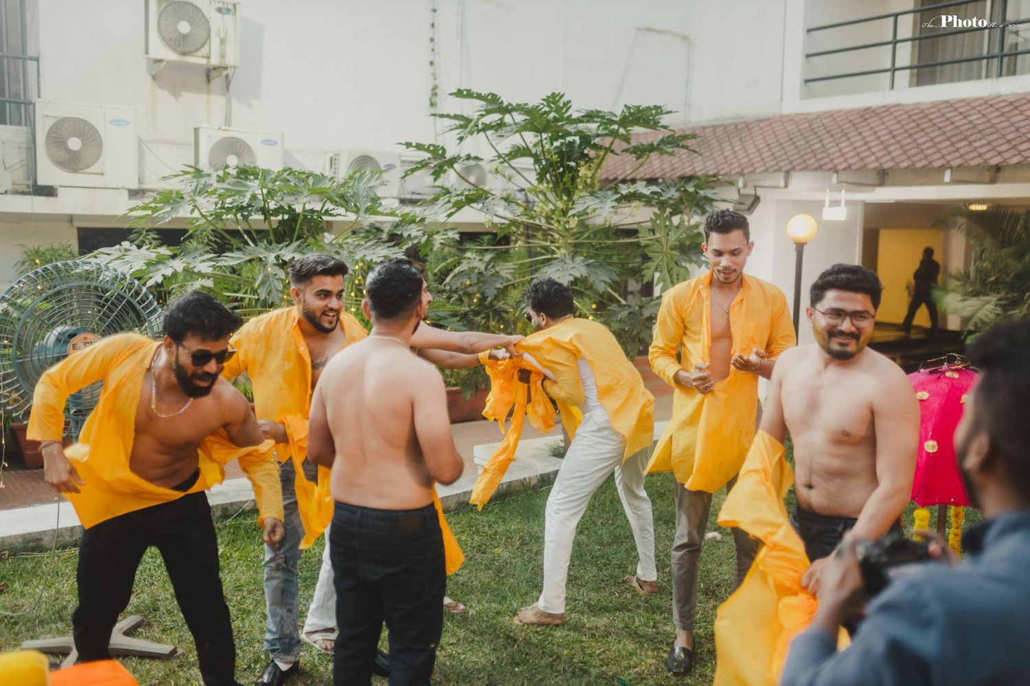 Outdoor celebration with participants in yellow attire enjoying traditional festivities.