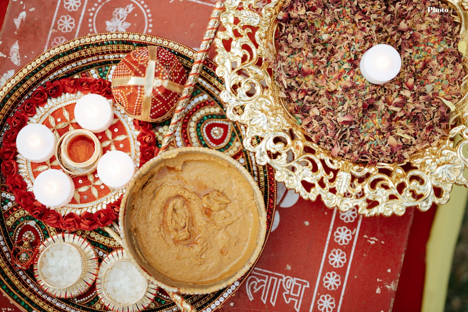 Ornate Indian wedding decorations featuring red and gold ceremonial items and plates.