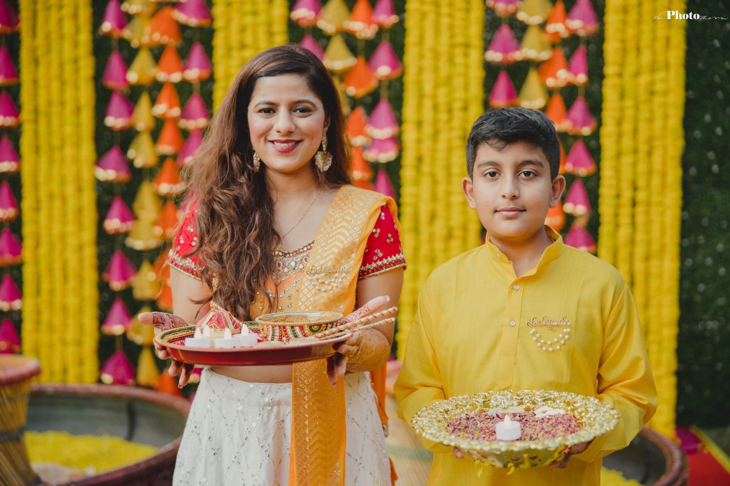 Wedding decor featuring bright yellow and pink floral arrangements against colorful backdrop.