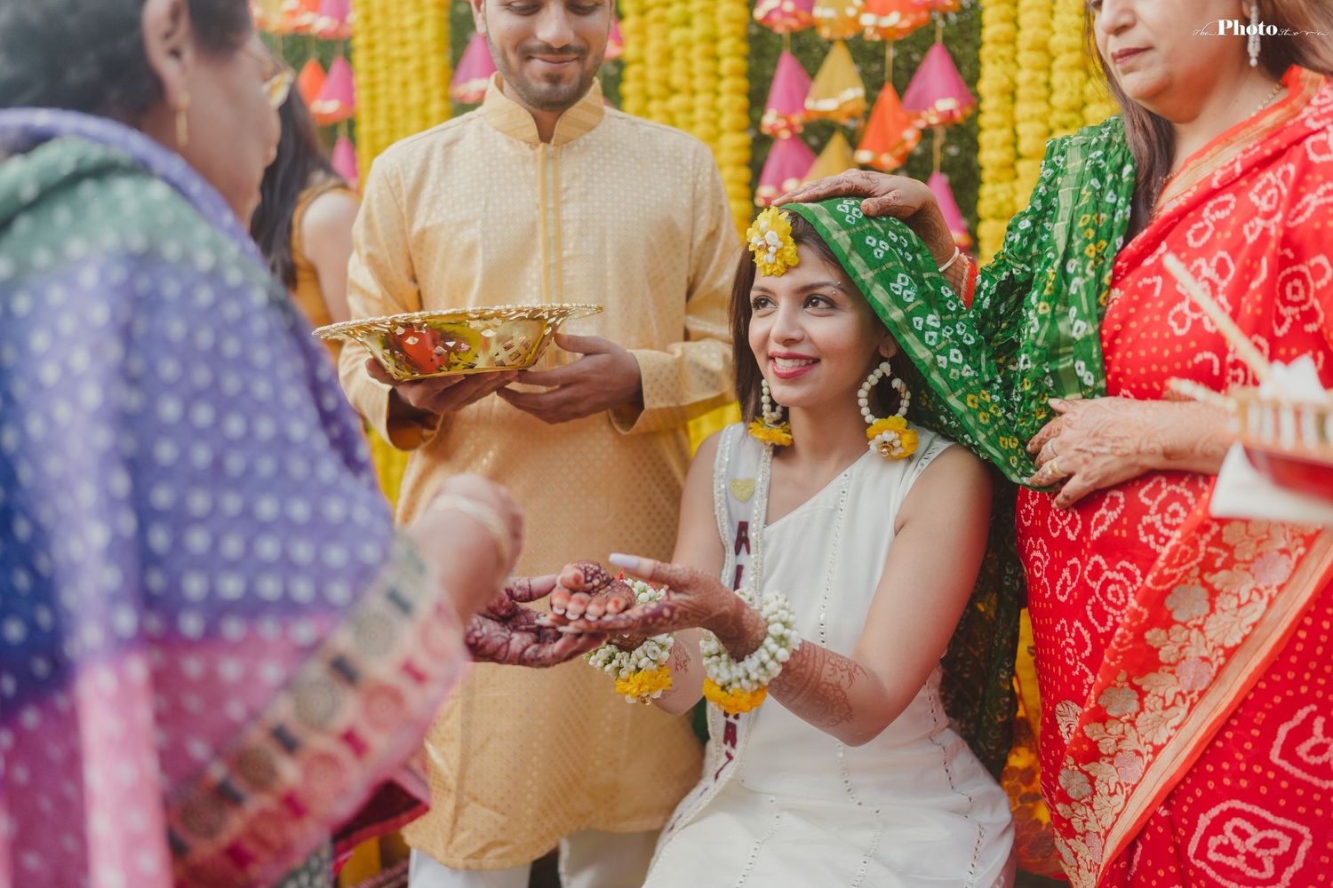 Guests celebrate at a colorful Indian wedding ceremony with yellow marigold decorations and traditional attire.