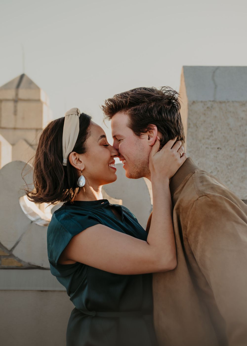 A tender moment shared between a couple on a rooftop during golden hour.