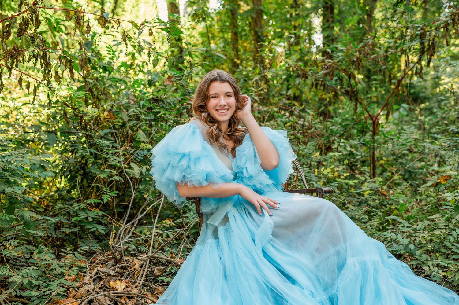 Dreamy outdoor photography session featuring flowing light blue gown in wooded setting.