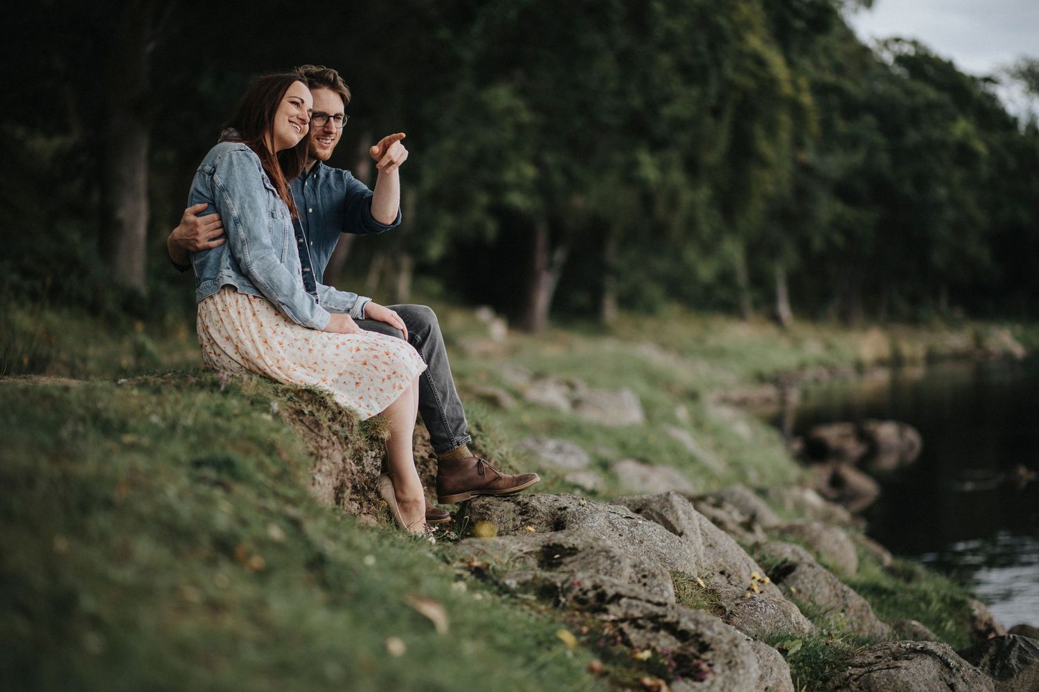 a couple sitting by a river