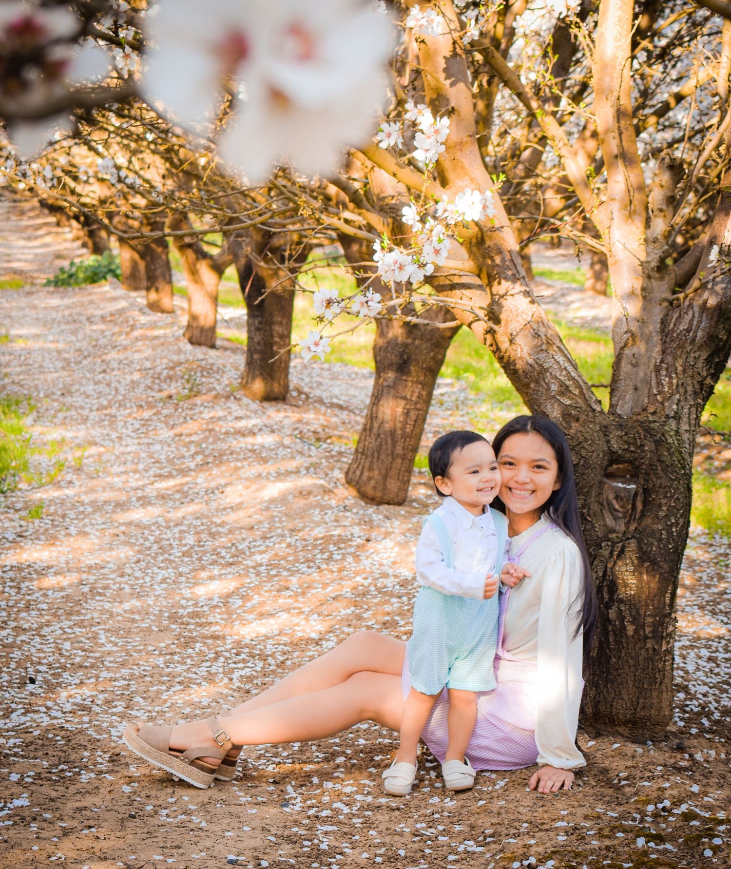 mom and toddler boy posing at the almond orchard