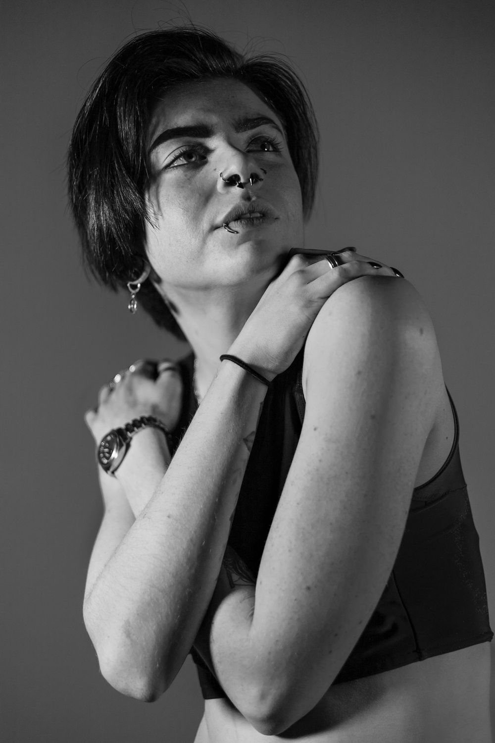 Dramatic black and white portrait showing hands covering face in expressive pose.