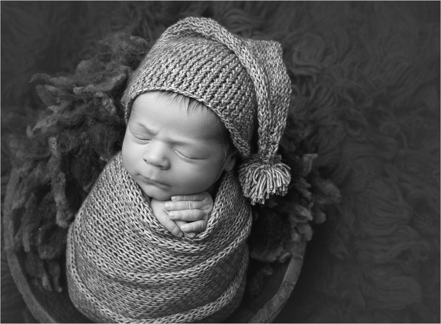 Austin newborn photographer vAlerie kay photography photo of swaddled newborn in black and white.  Wearing sleepy cap.