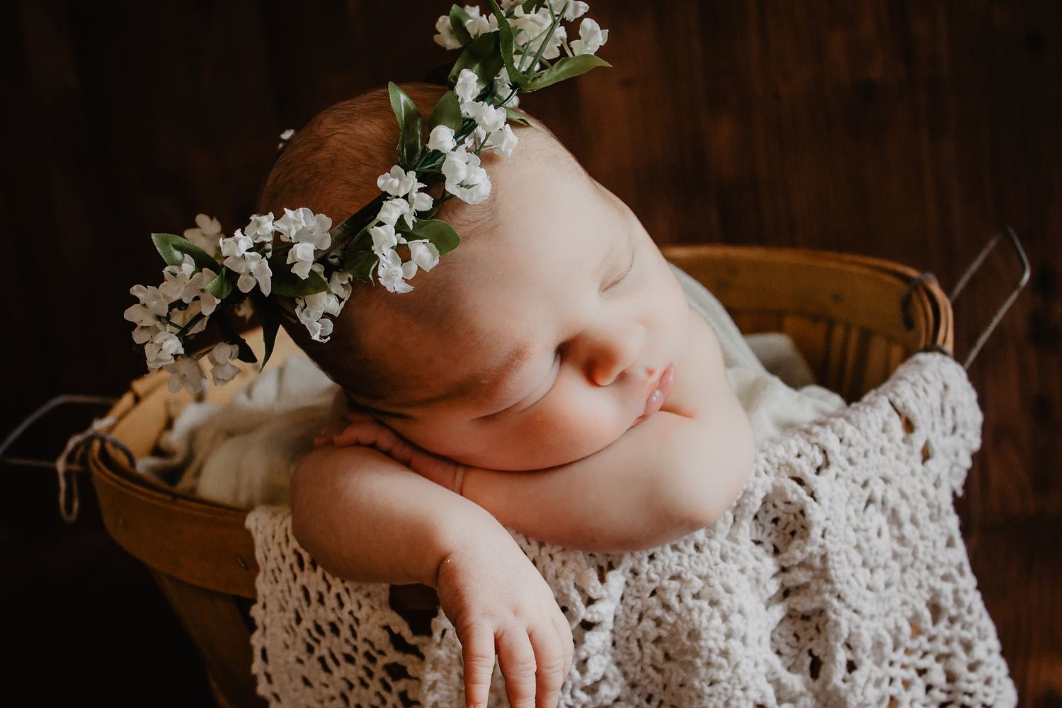 Delicate white flowers and lace fabric create soft textural composition in dark setting.