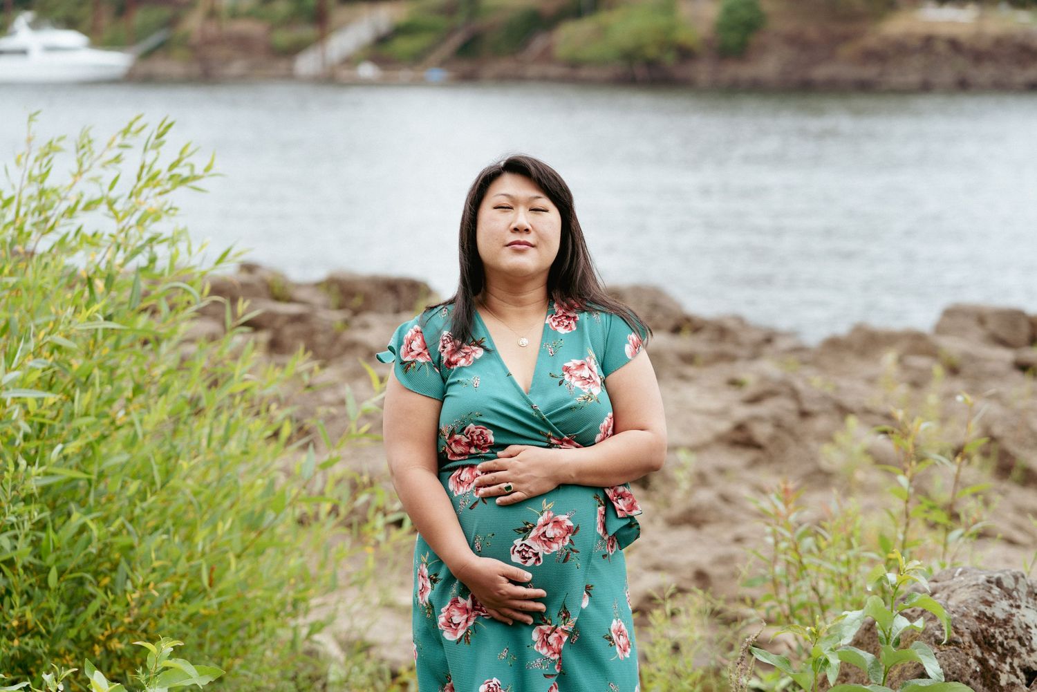 Solo maternity photo by Columbia River in Washington, summer session with bold floral dress.