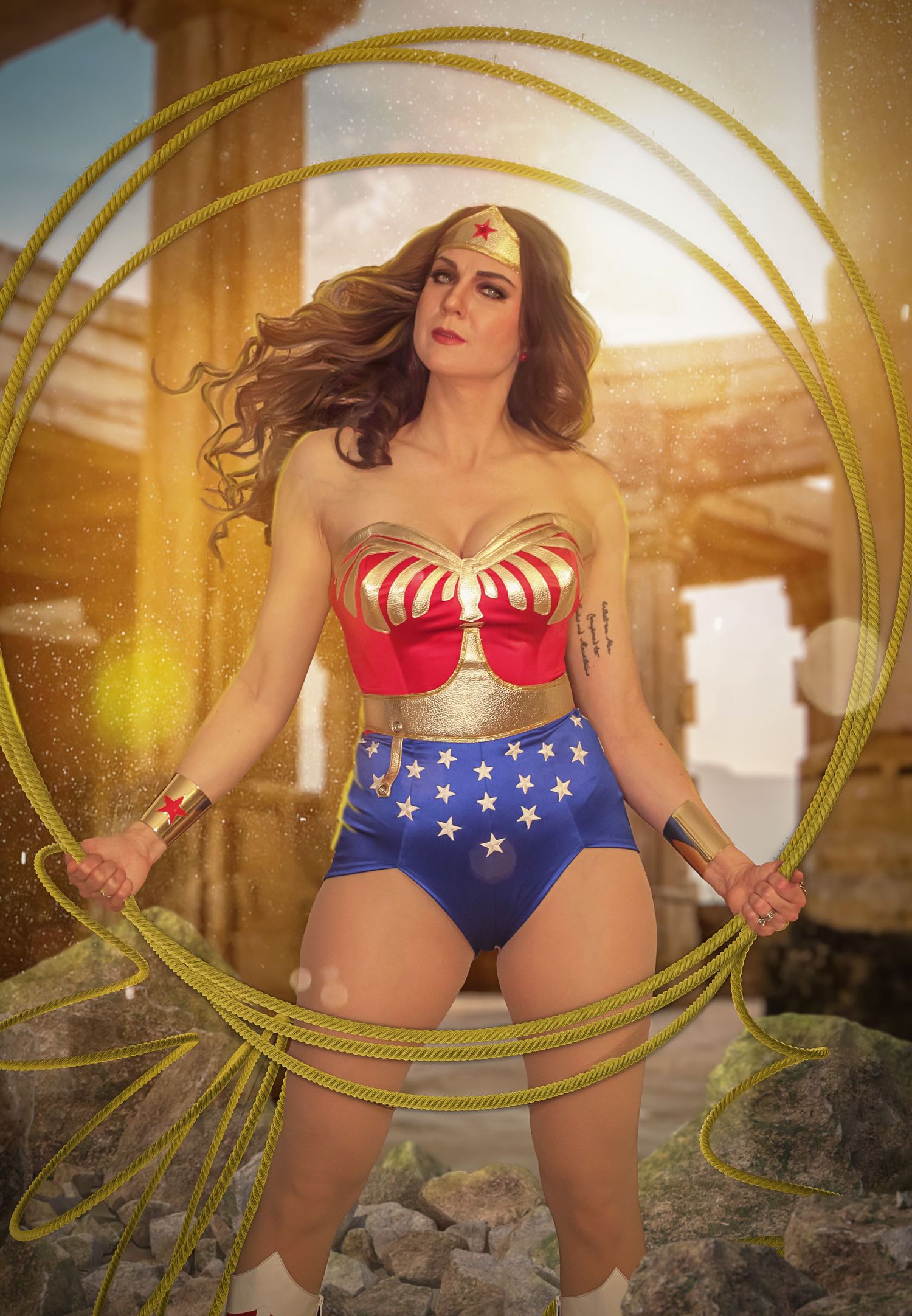 Wonder Woman cosplay with golden circles and sunlit background.