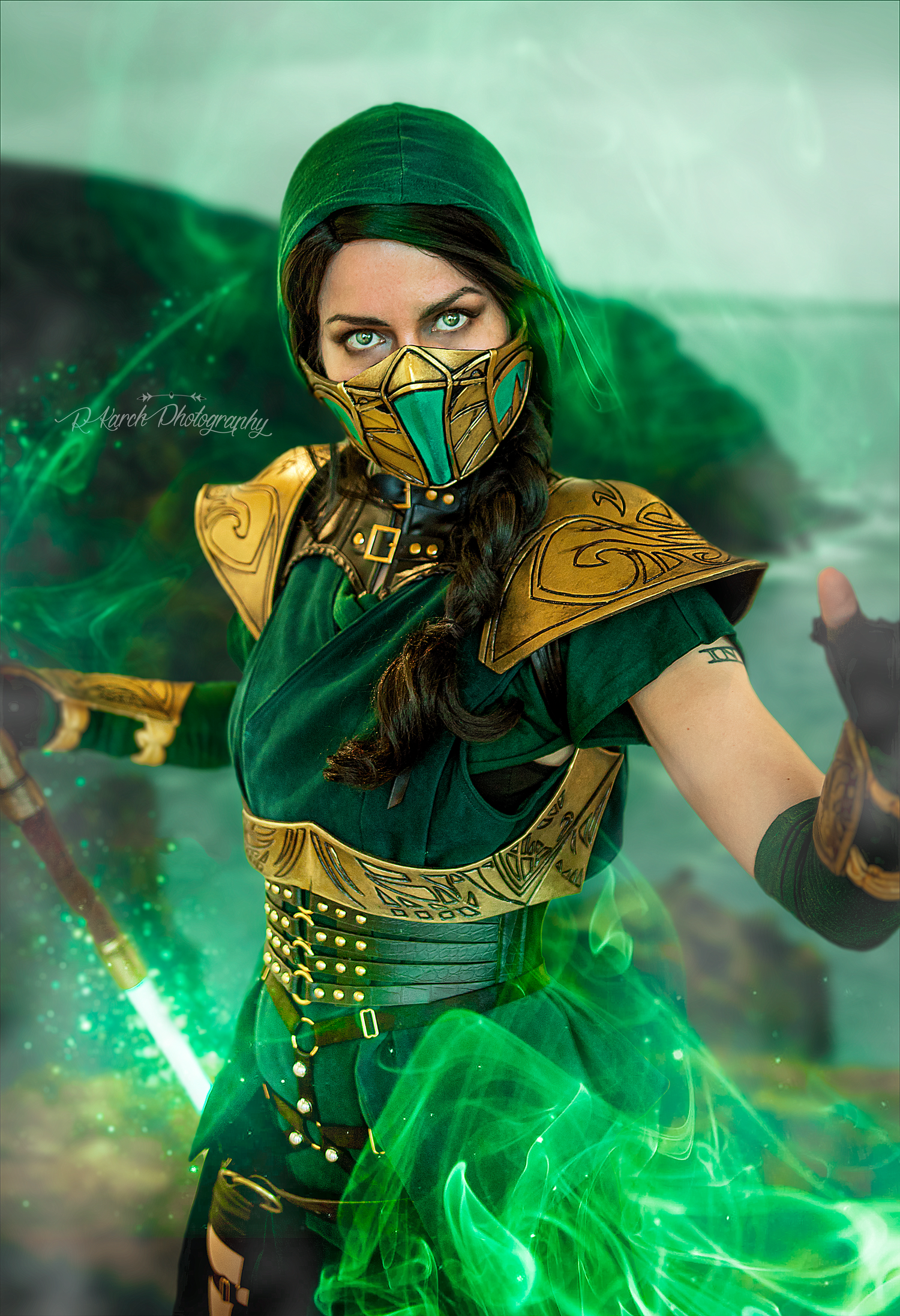 Fantasy cosplayer in ornate green and gold ninja outfit with mask poses in atmospheric lighting.