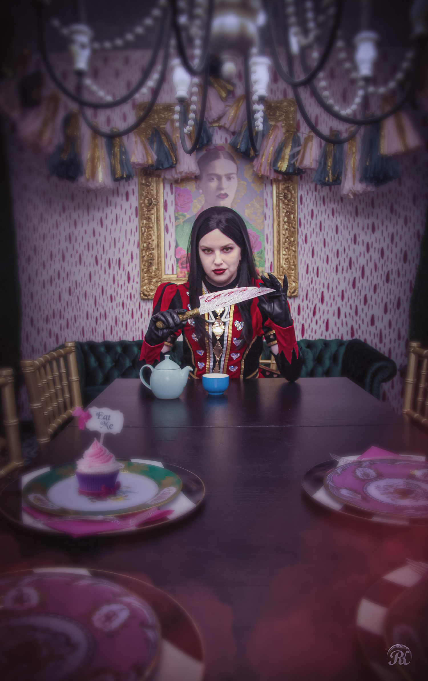 Gothic themed portrait at ornate dining table with teapot and dark decorative elements.