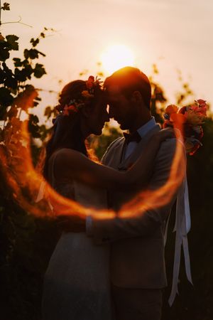 Romantic sunset silhouette with glowing ring of light and orange sky.
