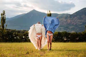 The bride and her maid of honor lift up her dress for a crazy photo on the wedding day in Piedmont valley