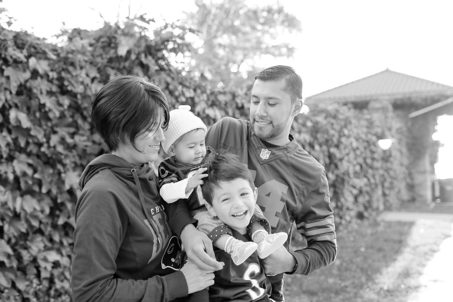 Black and white series of candid family moments showing affectionate interactions in an outdoor setting.